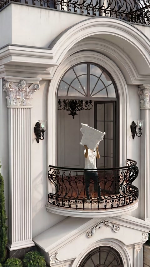 Maestro che solleva il capitello di colonna bianca decorativa sopra la testa nel balcone
