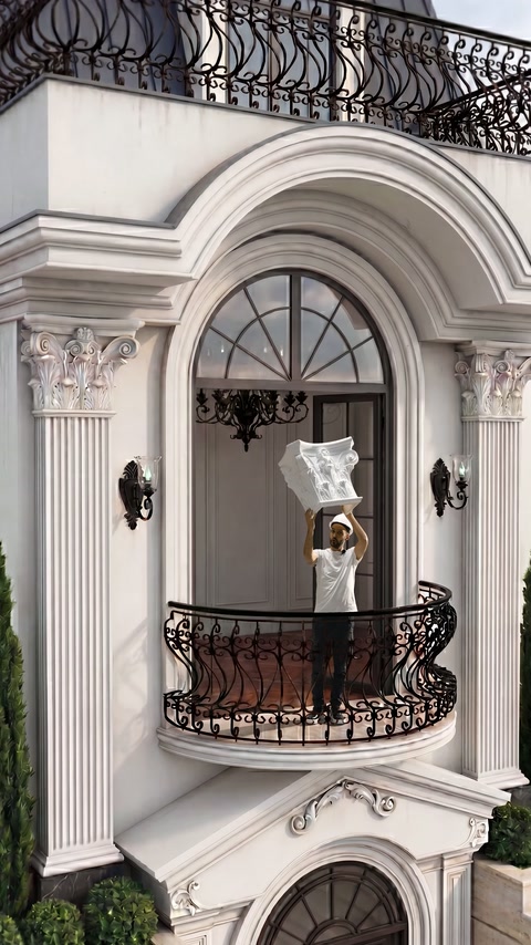 Capitello in poliuretano decorativo con lavorazioni sostenuto sopra la testa sul balcone ad arco