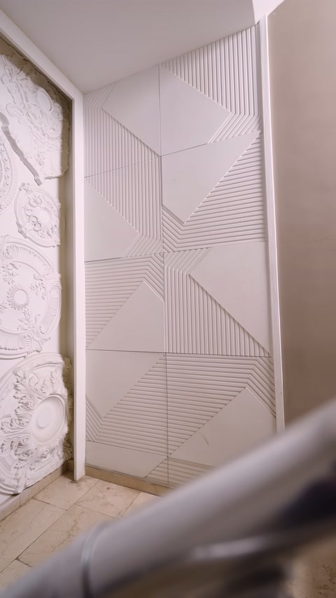Light-colored square panels cover stairwell wall with geometric patterns