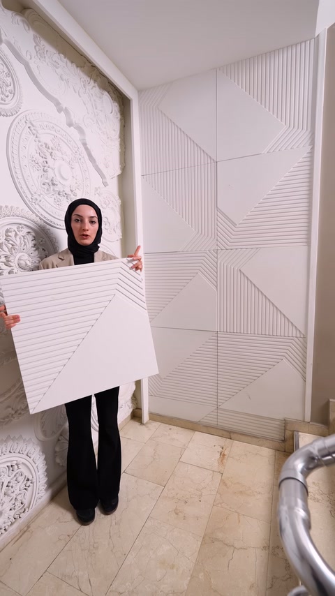 Server holds triangular-sectioned panel's embossed pattern toward camera