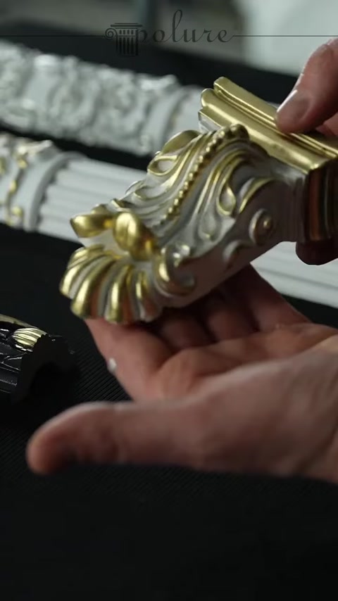 A decorative piece colored in gold and dark tones is displayed