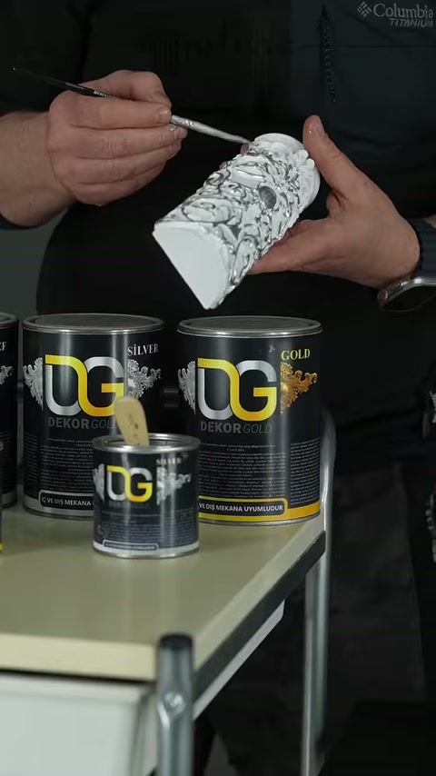 I dettagli in rilievo della decorazione in poliuretano vengono dipinti uno a uno con un pennello sottile