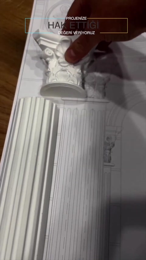 Un capitello decorato viene allineato manualmente con un fusto scanalato