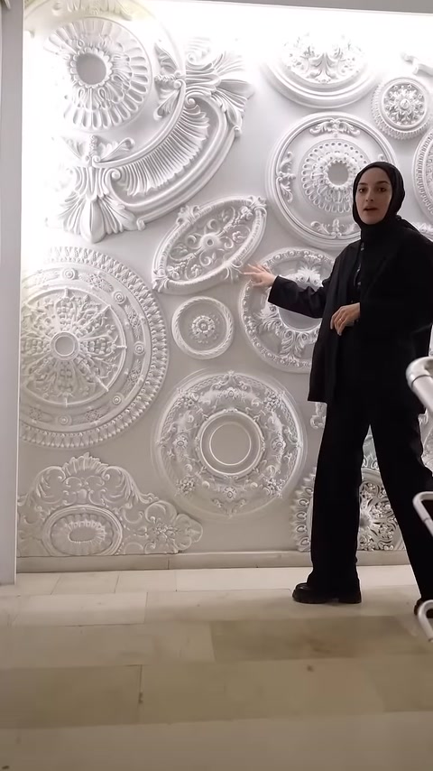 Il presentatore illustra i modelli di rilievi circolari grandi e piccoli sulla parete