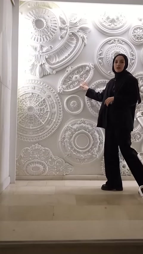 Il presentatore nello showroom illustra i rosoni da soffitto realizzati con diversi motivi