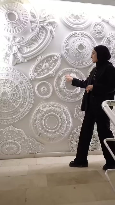Ornamenti circolari in poliuretano si trovano sulla parete dell'esposizione come campioni pre-installazione