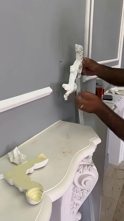 Un lungo elemento ornamentale decorato viene preparato per l'applicazione a parete