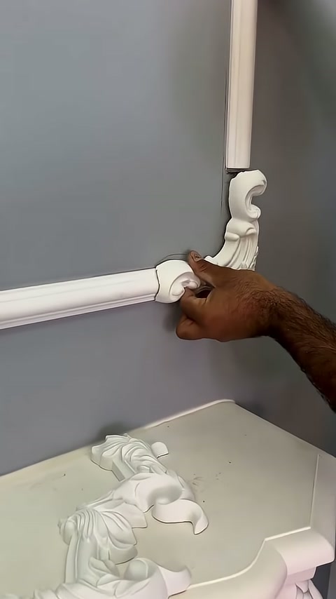A leaf-patterned corner element is being tested between two trim pieces