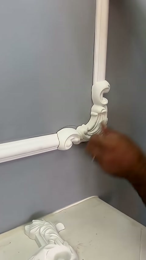 A craftsman aligns the decorative element upward along the vertical profile