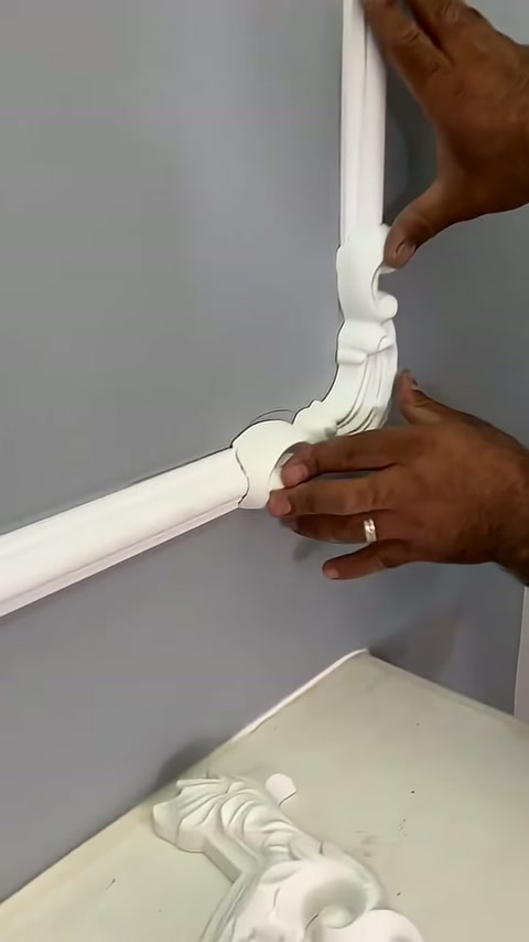 The position of the white ornament piece at the profile junction is being corrected by hand