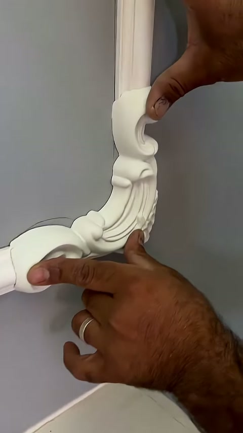 The ornamental piece at the trim corner is being checked with fingertips