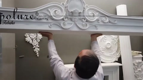 A decorative pediment detail with curved reliefs is shown in close-up