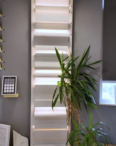 A decorative trim panel with concealed lighting is displayed beside a plant