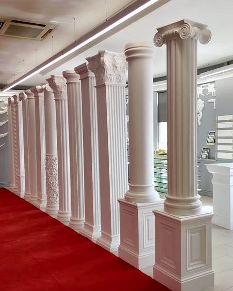 A row of columns extending along the red carpet is visible in the showroom