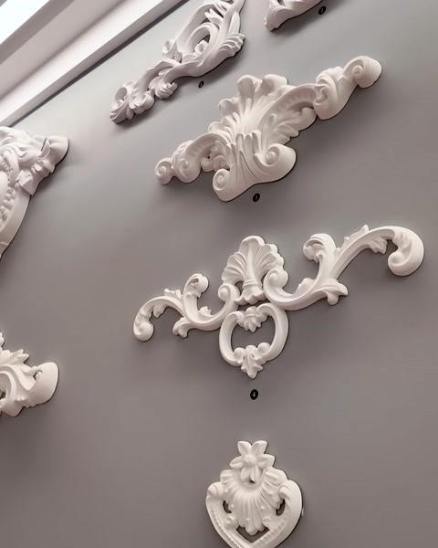 Small decorative appliques are shown mounted on a gray wall