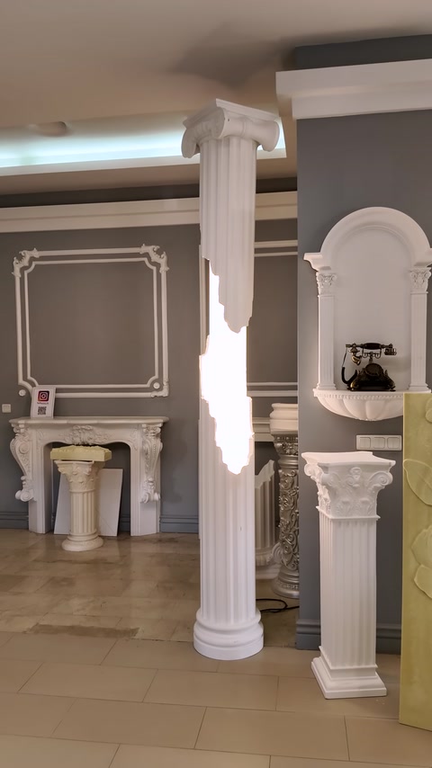 A showroom corner arranged with wall moldings, a fireplace, and columns