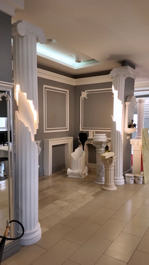 A sample interior featuring columns, wall moldings, and a fireplace arrangement