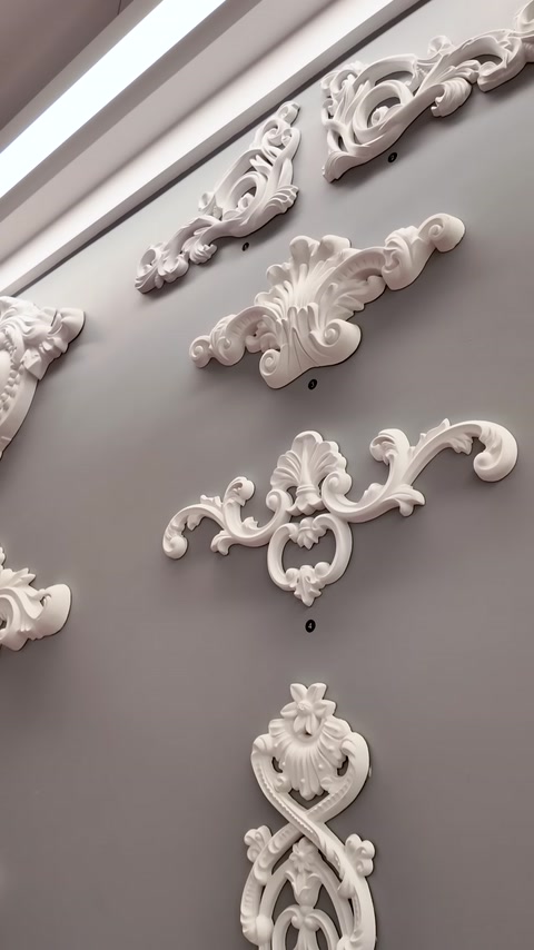 Decorazioni floreali e fogliate sinuose applicate su una parete grigia