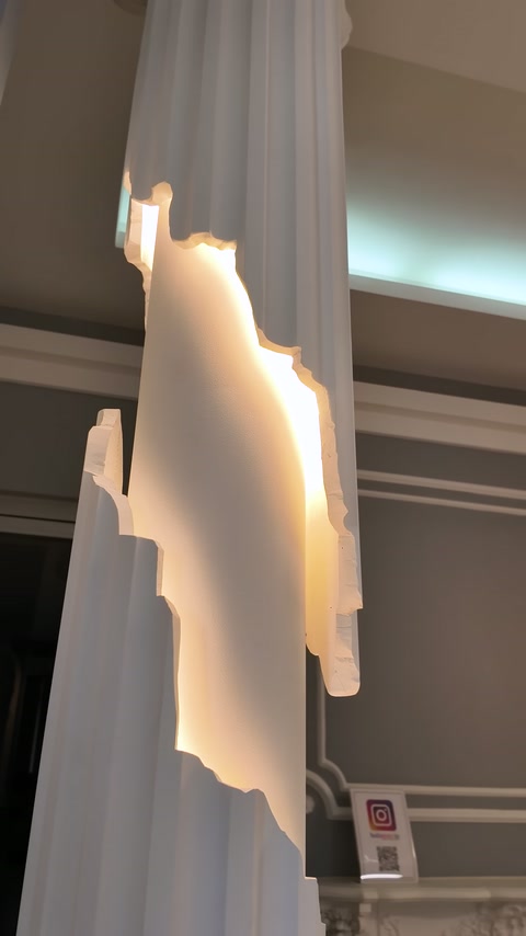 Backlit decorative wall element with irregular edges is shown in close-up.