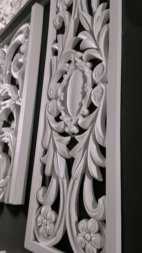 Long openwork panel with floral curves stands on a black background.
