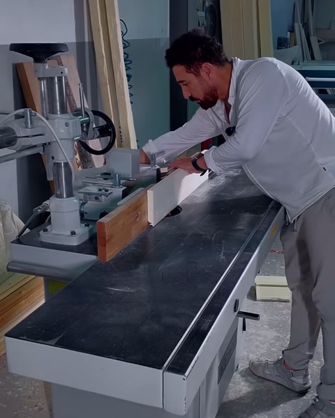 Taglio ad angolo di un profilo di cornice in poliuretano sulla sega