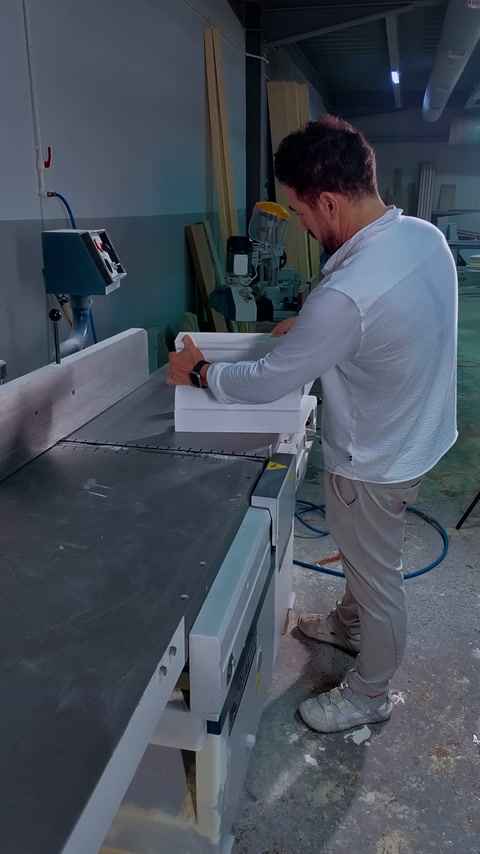 Craftsman aligns a short cornice section against the saw fence.