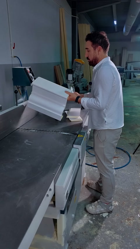 Craftsman rotates paired cornice mouldings to examine their matching profiles.