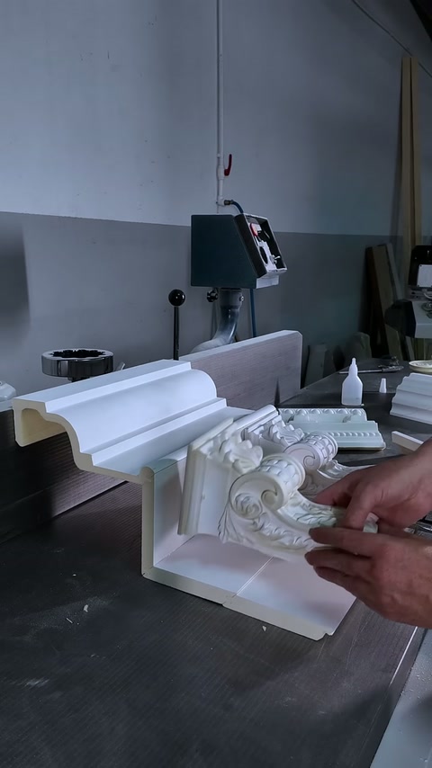 Decorative corner ornament is positioned beneath layered cornice on the workbench.