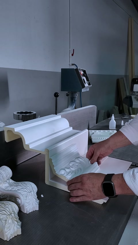 Worker presses the floral corner ornament into the moulding junction.