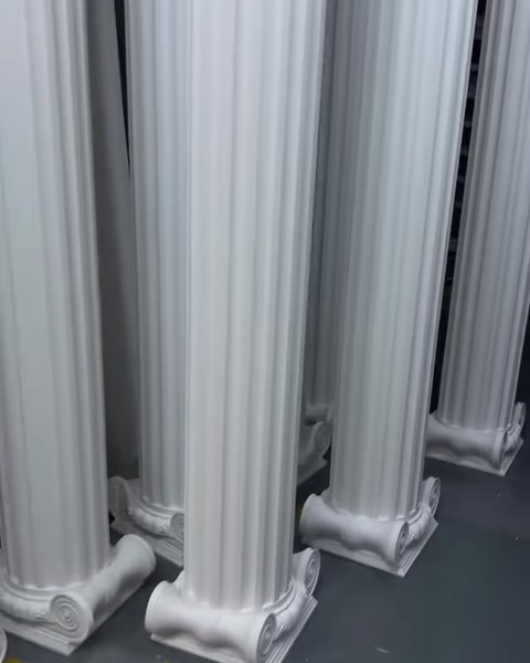 Colonne decorative bianche di diverso spessore sono esposte in posizione verticale