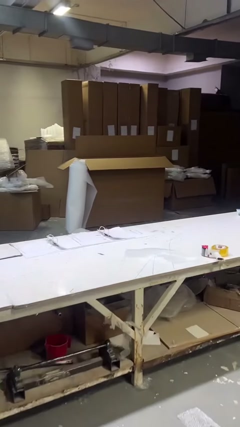 Atölyedeki geniş üretim masası paketleme malzemelerinin önünde yer alıyor