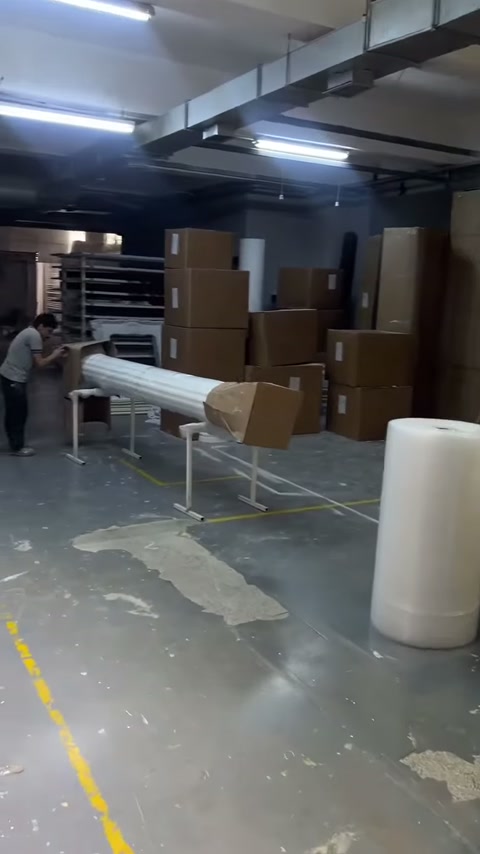Çalışan yatay duran uzun sütun gövdesinin ambalajını çözmeye başlıyor