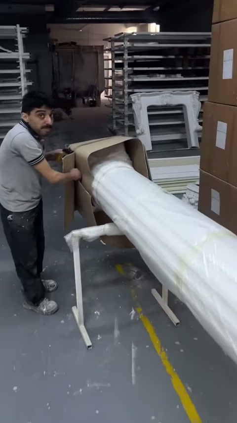 Sütun gövdesini saran karton koruma çalışan tarafından kesiliyor