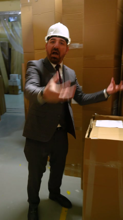 L'addetto descrive il controllo del prodotto con entrambe le mani nel deposito.