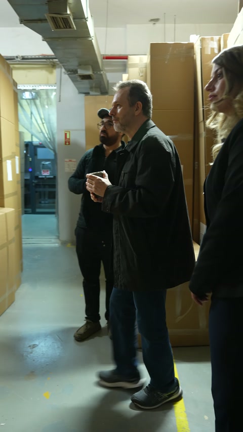 I clienti esaminano da vicino le etichette dei pacchetti verticali nel deposito della fabbrica.