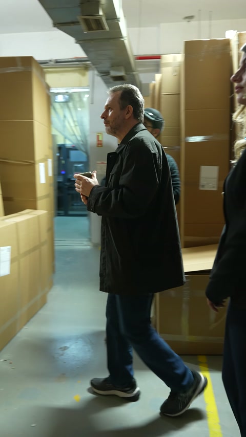 Un cliente ascolta l'addetto accanto ai prodotti decorativi confezionati.