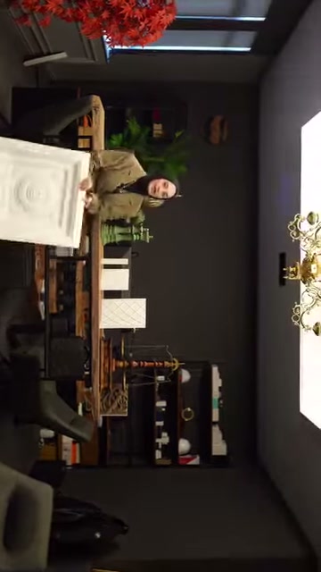 Il proprietario tiene verso la telecamera un campione di rosone quadrato in poliuretano presso lo showroom