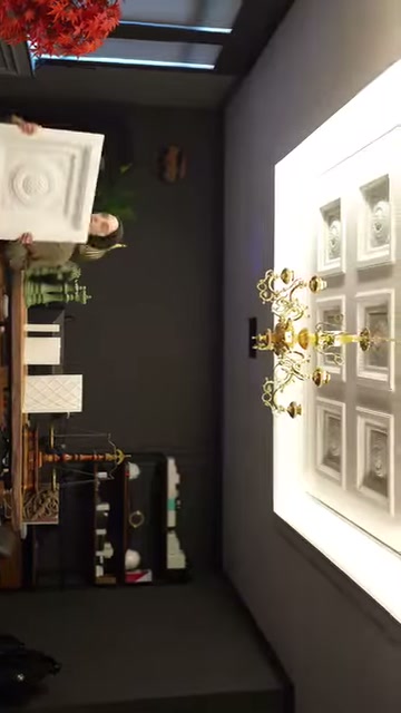 Un campione di rosone decorativo bianco viene mostrato frontalmente nella mano del proprietario