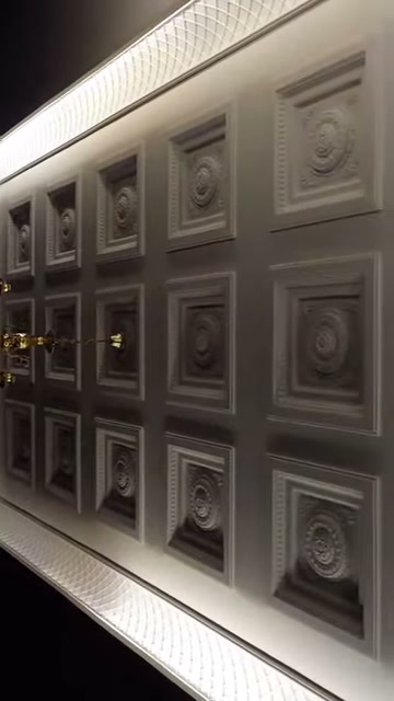 I pannelli di rosone simmetrici sul soffitto della showroom vengono ripresi da vicino