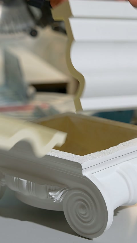 Carved decorative profiles with cut edges are lined up side by side on the workbench
