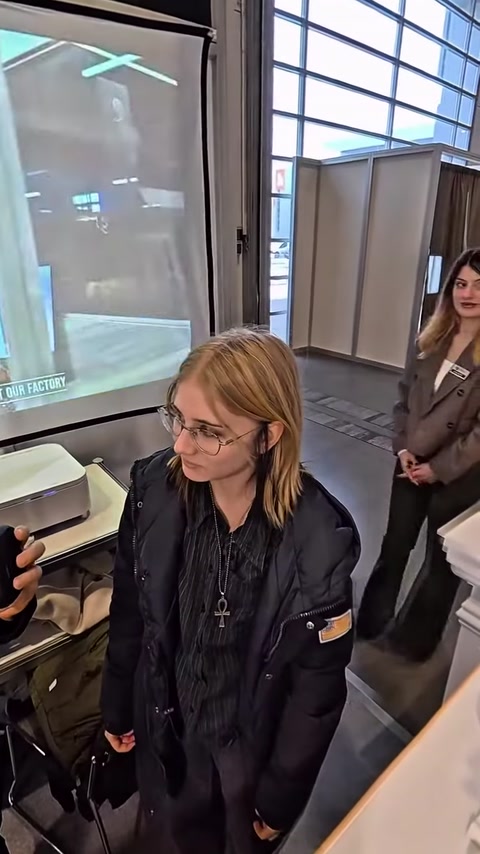 Un visitatore esamina un visore VR preparandosi alla presentazione architettonica.