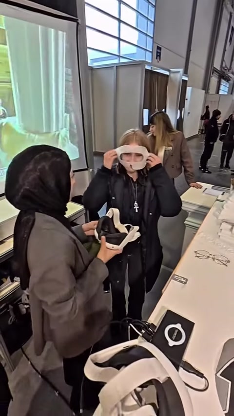 Un addetto prepara il visore VR per l'utilizzo da parte di un visitatore.
