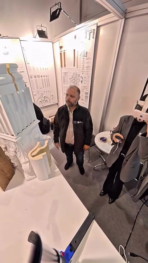 Un visitatore si prepara a usare un visore VR accanto ai modellini di colonne.