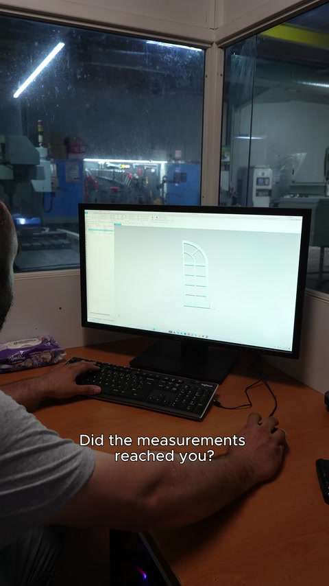 A CNC operator checks the drawing of the arched panel to be machined on the screen