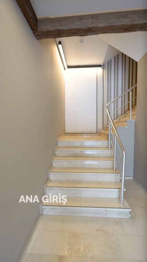 Aydınlatmalı merdivenlerde dikey duvar çıtaları ve sade giriş düzeni