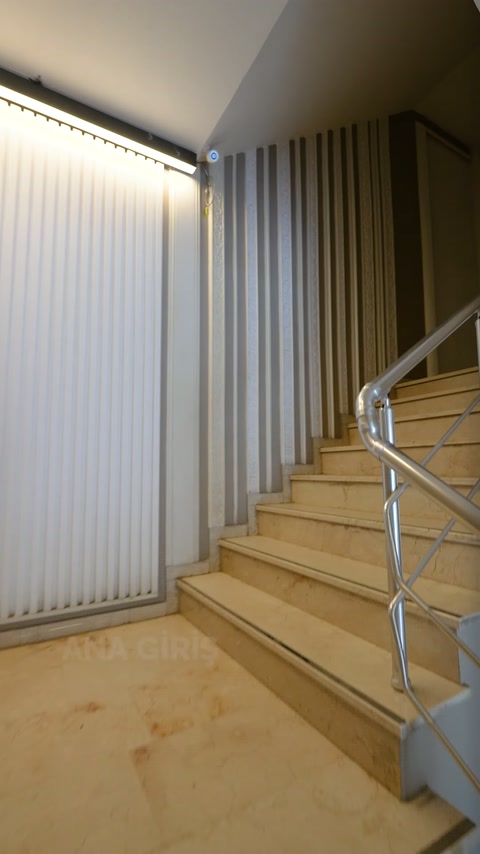Il rivestimento murale a stecche verticali lungo le scale è evidenziato dall'illuminazione