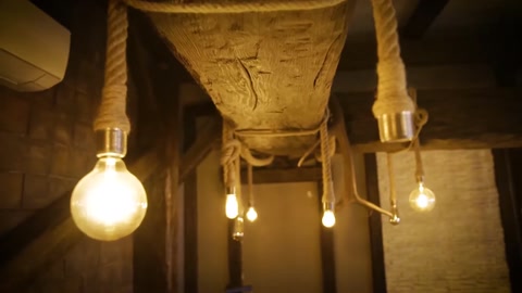 Lampadine dalla luce calda disposte sotto travi rustiche per soffitto