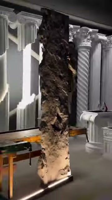 The lower section of a standing rock-look panel is illuminated from the floor