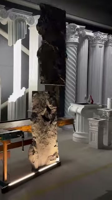 The recessed surface of a long panel is shown between decorative columns