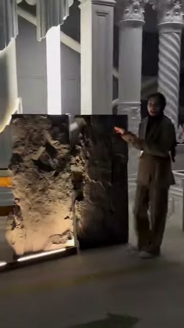 A staff member introduces two decorative panels standing side by side